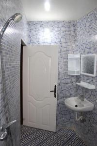 baño con puerta blanca y lavamanos en Tafoukt house ,tamraght, en Aourir