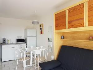 a kitchen with a table and chairs and a refrigerator at Cap d'Agde Antinea, Plage Rochelongue, Piscine et Parking in Cap d'Agde