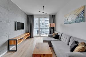 a living room with a couch and a table at Bastion Wałowa by Q4Apartments in Gdańsk