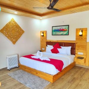 1 dormitorio con 1 cama grande con almohadas rojas y blancas en The Mountilla Resort, en Tehri-Garhwāl