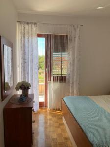 sypialnia z łóżkiem i dużym oknem w obiekcie Villa Blue w mieście Zaton