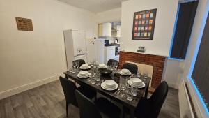 a dining room with a table and chairs and a refrigerator at SAV Apartments - Russell, Luton (4 Bed House) in Luton