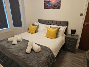 a bedroom with a large bed with yellow pillows at SAV Apartments - Russell, Luton (4 Bed House) in Luton