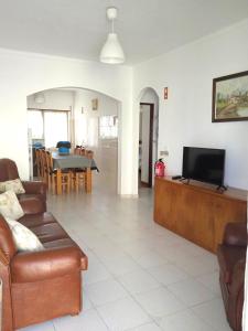a living room with a couch and a flat screen tv at Baleal Sol Alojamentos in Baleal