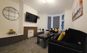 a living room with a couch and a fireplace at SAV Apartments - Russell, Luton (4 Bed House) in Luton