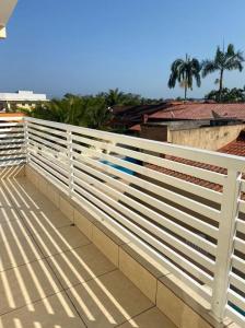 een wit hek aan de zijkant van een gebouw bij Beachouse Marissol Morada da Praia in Bertioga