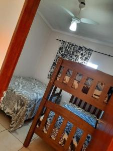 een slaapkamer met een bed en een houten ladder bij Beachouse Marissol Morada da Praia in Bertioga