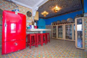 a kitchen with a red refrigerator and red bar stools at Amazing view and unique design in historic medina in Chefchaouene