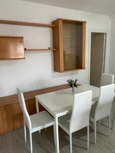 a dining room with a white table and white chairs at Precioso Apartamento en Puertollano in Puertollano