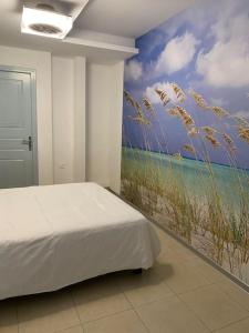 1 dormitorio con un mural de playa y césped en Αρέθουσα Jungle τριάρι 65τμ. en Chalkida