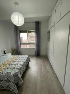 - une chambre avec un lit et une grande fenêtre dans l'établissement Precioso Apartamento en Puertollano, à Puertollano