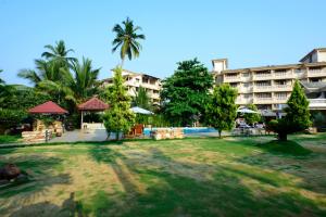 a resort with a large building in the background at La Grace Resort in Benaulim