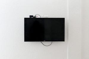 uma televisão de ecrã plano pendurada numa parede em Titrit House awrir em Aourir