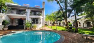 a house with a swimming pool in front of a house at Jacaranda Lodge in Victoria Falls