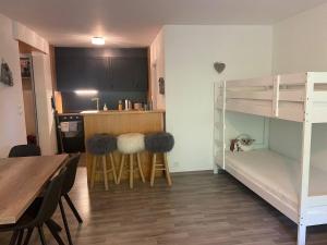 ein kleines Zimmer mit einem Etagenbett und einem Tisch in der Unterkunft Grand Studio au centre de Crans in Crans-Montana