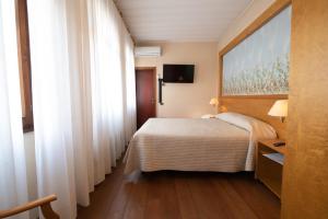 a hotel room with a bed and a window at Residence La Fenice in Padova