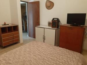 sypialnia z łóżkiem i telewizorem na komodzie w obiekcie Casaquinta en Funes w mieście Funes