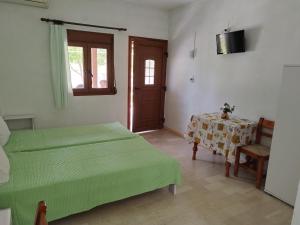 a bedroom with two beds and a table and a window at "Patra's" Apartments Patra in Poseidónion