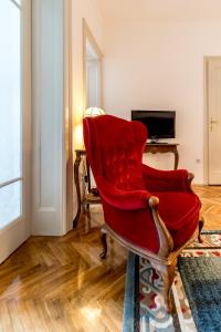 ein roter Stuhl in einem Wohnzimmer in der Unterkunft Apartment Kneza Milosa in Belgrad