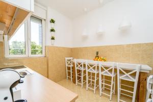 uma cozinha com um balcão e uma ilha de cozinha com bancos em Apartment Kneza Milosa em Belgrado