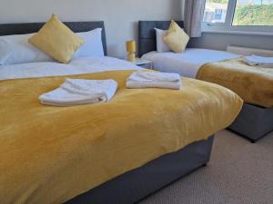 a bedroom with two beds with towels on them at 4 beds with links to motorways in Leeds