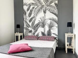 a bedroom with a large mural of palm trees at Les oiseaux du paradis in Sausset-les-Pins