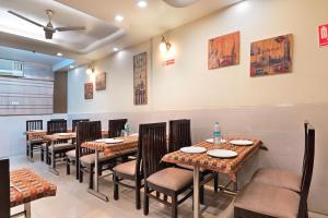 um restaurante com mesas e cadeiras num quarto em The Aster Karol Bagh Homely Atmosphere em Nova Deli