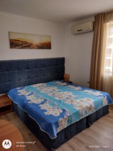 a bedroom with a bed with a blue comforter at Аз и Ти in Sunny Beach