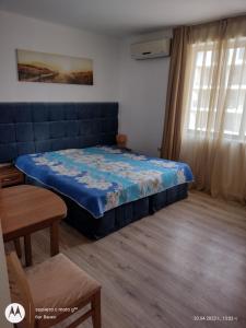 a bedroom with a bed and a table and a window at Аз и Ти in Sunny Beach