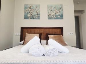 a bed with two white towels on top of it at Home Sweet Home junto a Mezquita / Wifi / Parking in Córdoba