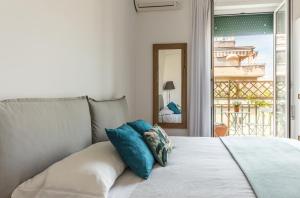 ローマにあるTorripa Group - Pratiの白いベッド(青い枕付)が備わるベッドルームです。