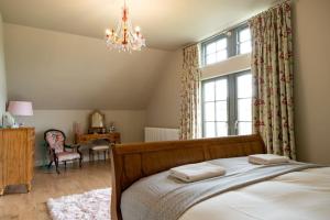 a bedroom with a bed and a chandelier at Escape Ordinary at Lough Erne Golf Village No.52 in Enniskillen