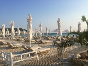 a beach with chairs and umbrellas and the ocean at Sani Garden House in Sani Beach