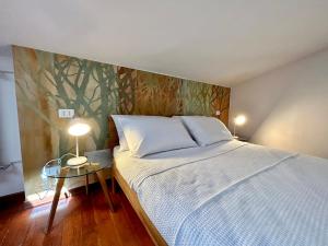 ein Schlafzimmer mit einem Bett und einem Tisch mit einer Lampe in der Unterkunft SUNFLOWER APARTMENT in Peschiera del Garda