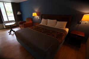 a hotel room with a large bed and a chair at 121 Motel Battleboro in Battleboro