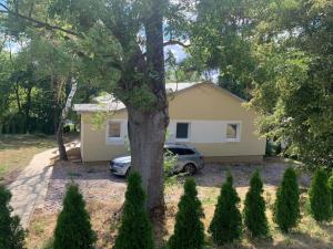a car parked in front of a house with a tree at Chata nad kúpaliskom Santovka in Santovka
