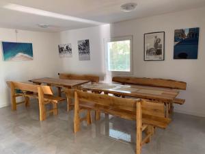 a dining room with wooden tables and benches at Chata nad kúpaliskom Santovka in Santovka