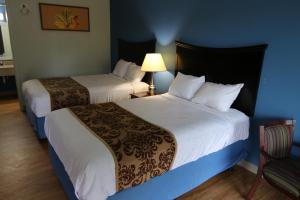 a hotel room with two beds and a chair at 121 Motel Battleboro in Battleboro