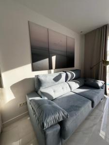 een woonkamer met een blauwe bank met kussens bij Apartment Malibu Sun & Relax in Adeje