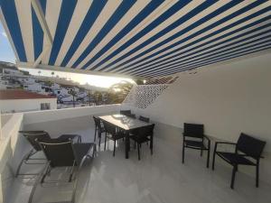 a dining room with a table and chairs on a balcony at Apartment Malibu Sun & Relax in Adeje