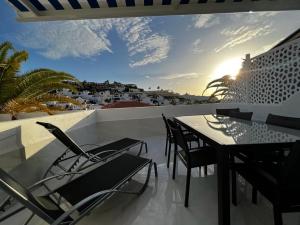een patio met een tafel en stoelen op een balkon bij Apartment Malibu Sun & Relax in Adeje