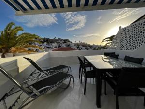 een tafel en stoelen op een balkon met uitzicht bij Apartment Malibu Sun & Relax in Adeje