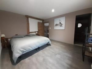 ein Schlafzimmer mit einem großen Bett in einem Zimmer in der Unterkunft Aux Portes de Vrupt in Saint-Nabord