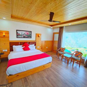 1 dormitorio con 1 cama grande, mesa y sillas en The Mountilla Resort, en Tehri-Garhwāl