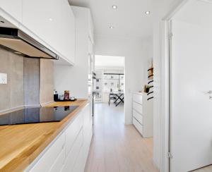 een keuken met witte kasten en houten vloeren bij Moderne lejlighed med privat parkering in Randers