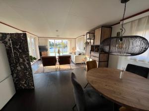 een woonkamer met een eettafel en een woonkamer bij Chalet Havenzicht Eernewoude in Earnewâld