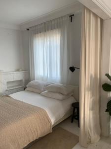 a white bedroom with a bed and a window at CASA SCANDIC FAMILY GUEST HOUSE rooms&apartments in Matosinhos