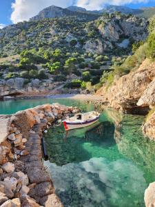 a boat is docked in a body of water at Agrilia Koromili Retreat in Paralia Livadostratas