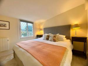 a bedroom with a large bed and a window at Pretty 1 bedroom cottage near Cirencester in Purton