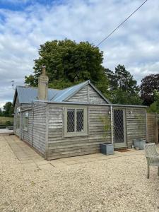 a small house with a bench in front of it at Pretty 1 bedroom cottage near Cirencester in Purton